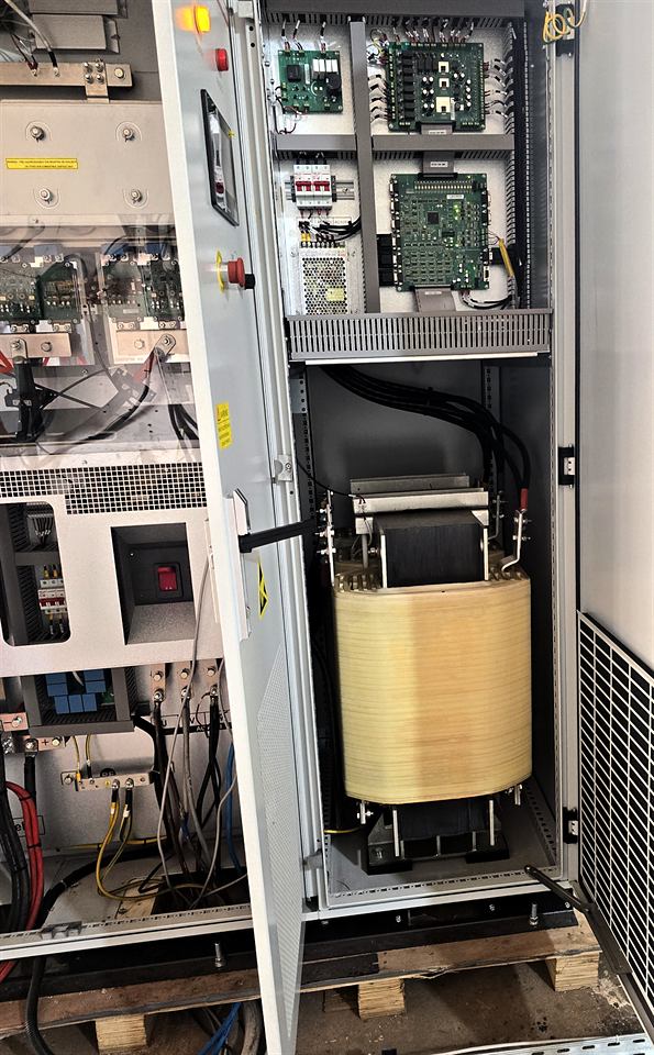 Vue rapprochée d'une armoire industrielle ouverte, composants de puissance et transformateur