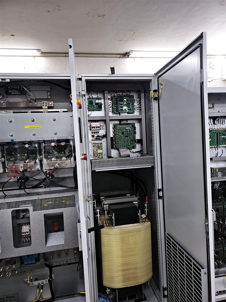 Armoire industrielle ouverte avec un transformateur jaune dans la partie basse