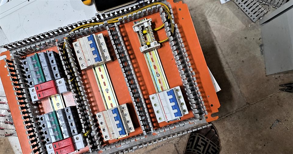 Coffret orange vu de dessus, disjoncteurs et rails de raccordement alignés