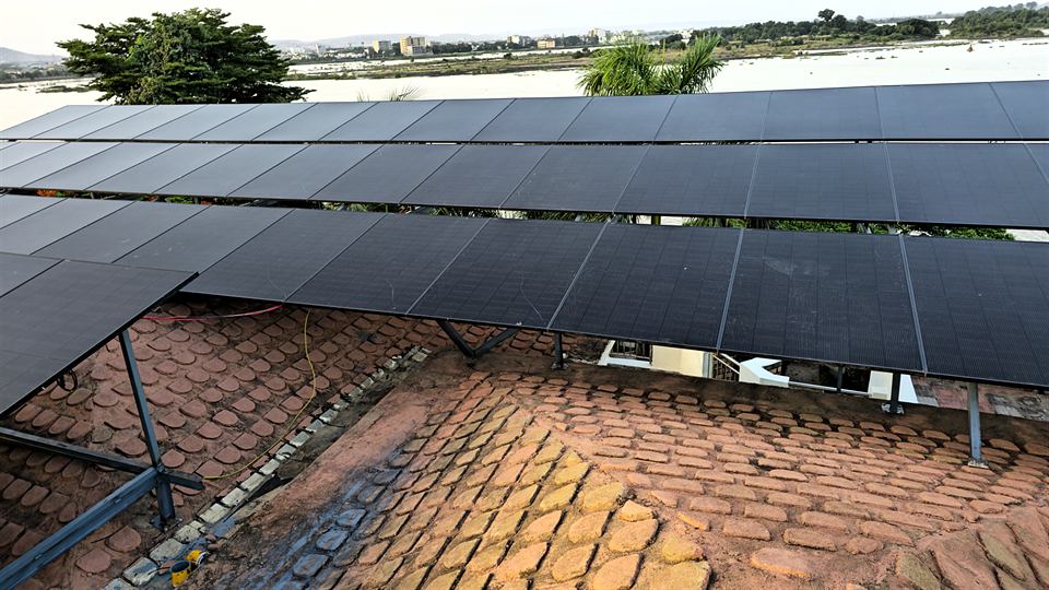 Modules solaires sombres montés sur une charpente au-dessus d'une toiture en tuiles