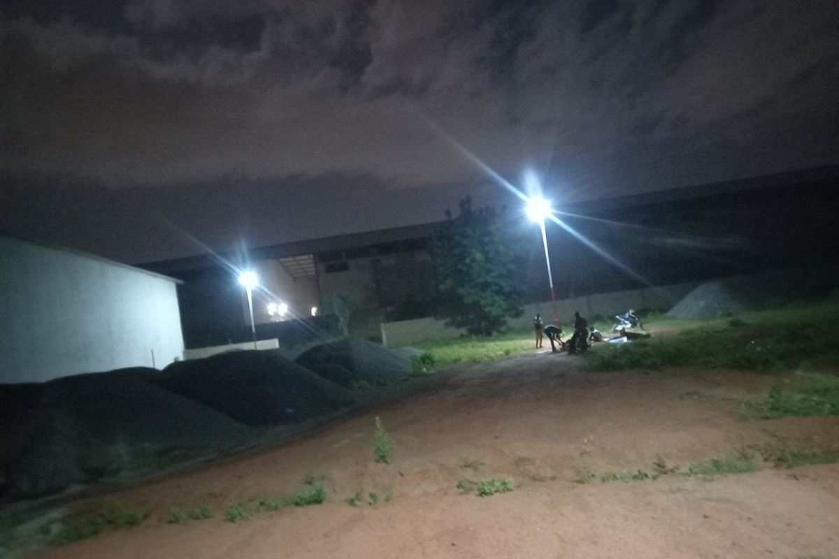 Deux mâts d'éclairage solaire allumés de nuit au-dessus d'un chemin en terre