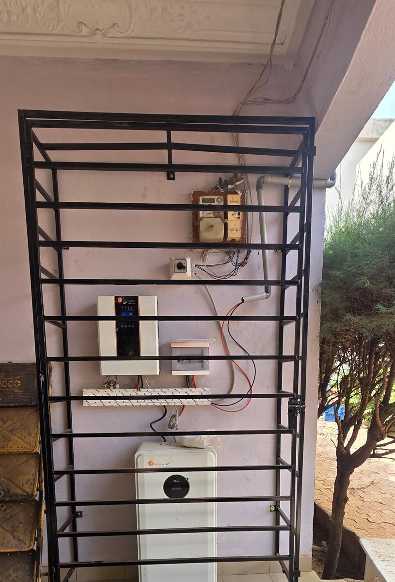 Onduleur et batterie derrière une grille de protection