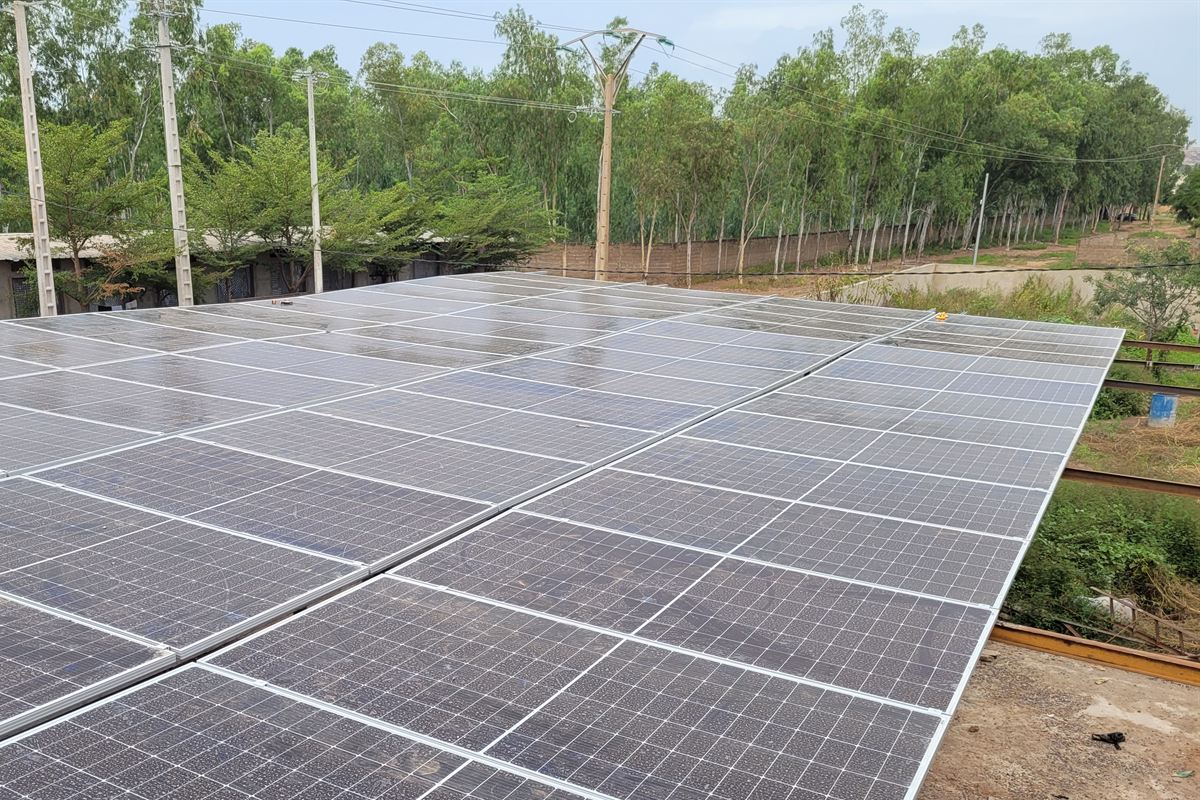 Grand champ de modules sur charpente, deux-roues garés en dessous